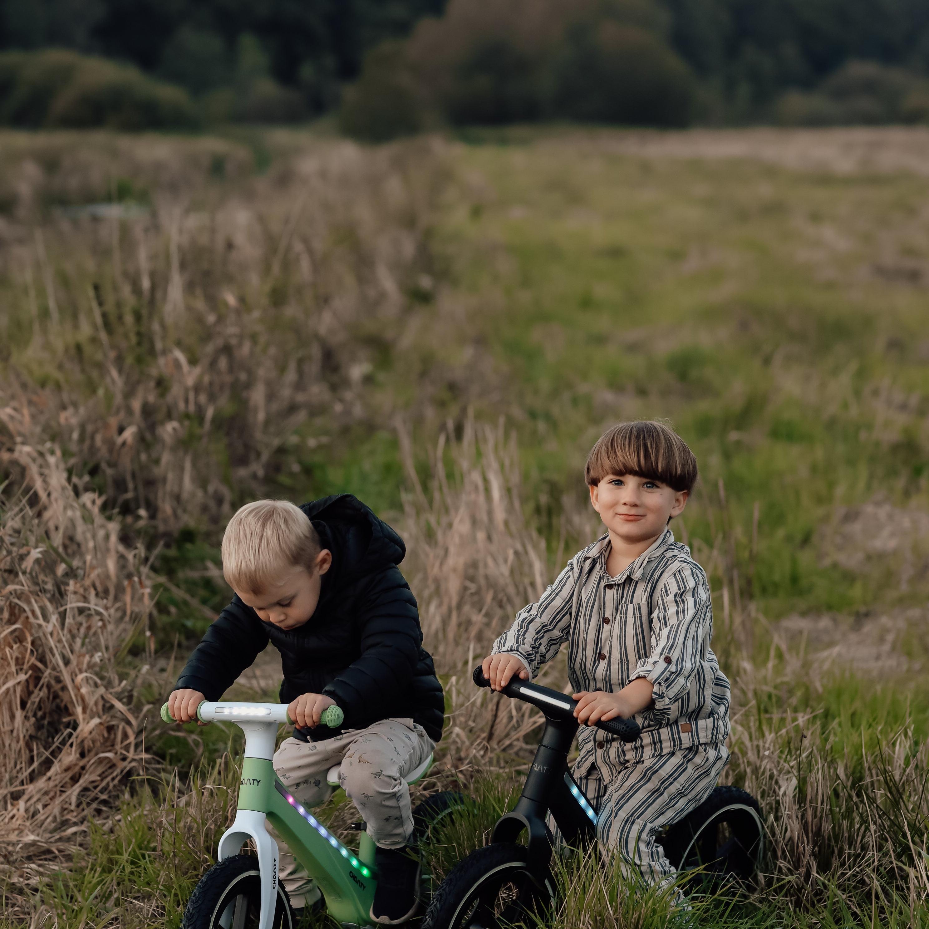 Kinder fahren Chanty-Laufräder draußen.