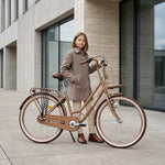 Mädchen mit Fahrrad vor Gebäude.