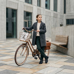 Mädchen mit Fahrrad im Stadtbild.