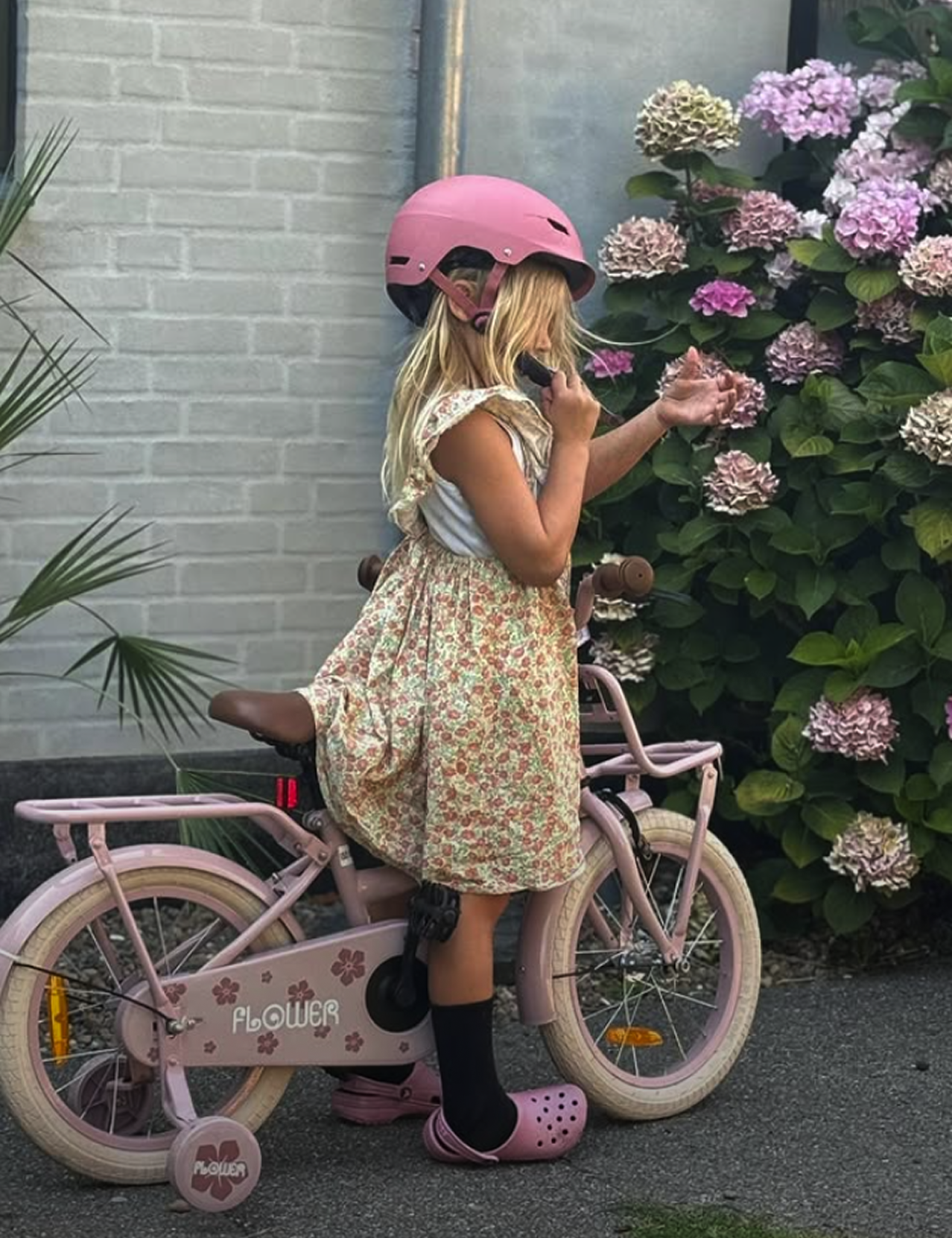Kind mit rosa Fahrradhelm.