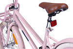 Brauner Fahrradsattel an einem rosa Rahmen mit rotem Reflektor